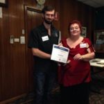 Fiona Hartnett, Mentor, presents a participation certificate.